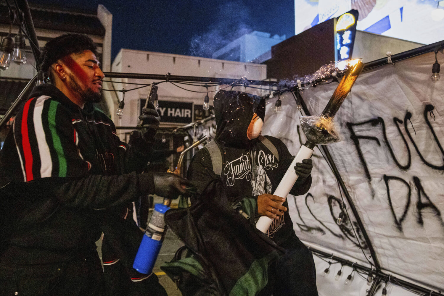Protesters prepare to launch projectiles during protests over the Trump administration's immigratio...