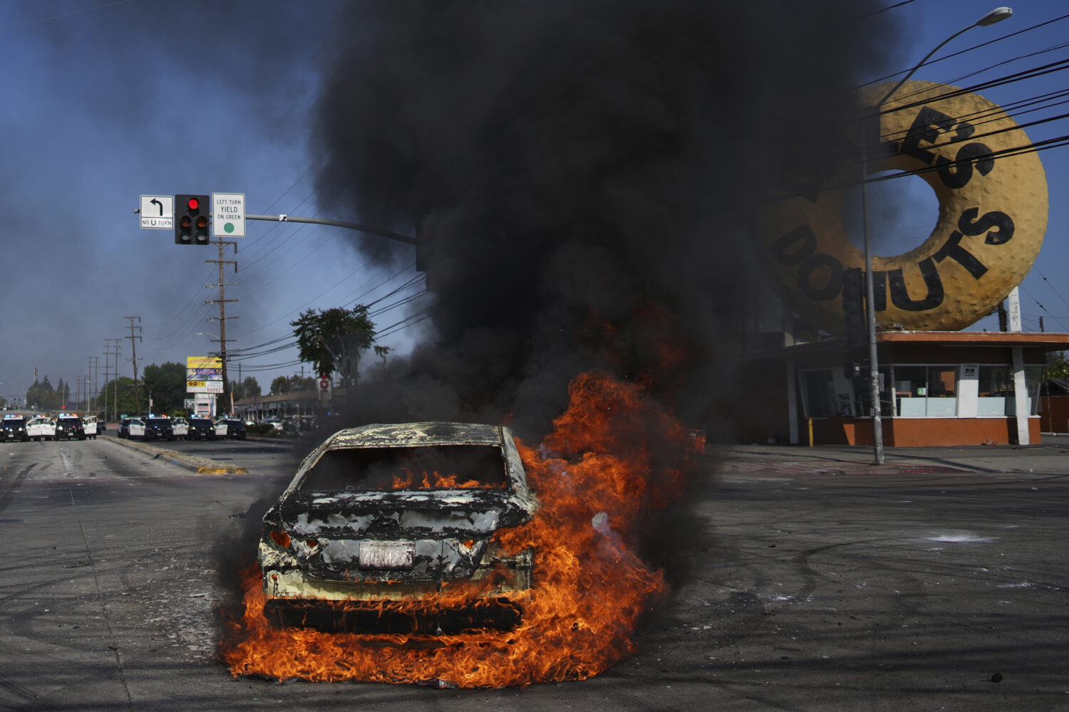A car burns during a protest in Compton, Calif., Saturday, June 7, 2025, after federal immigration ...