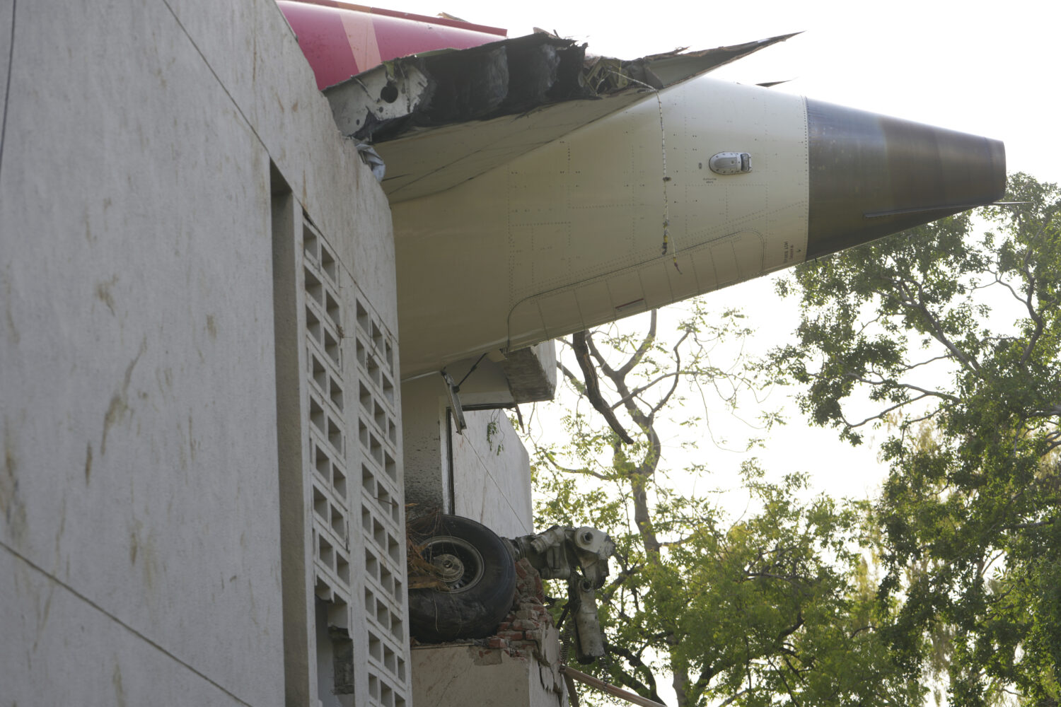 The debris of an airplane sticks out of a building after it crashed in India's northwestern city of...