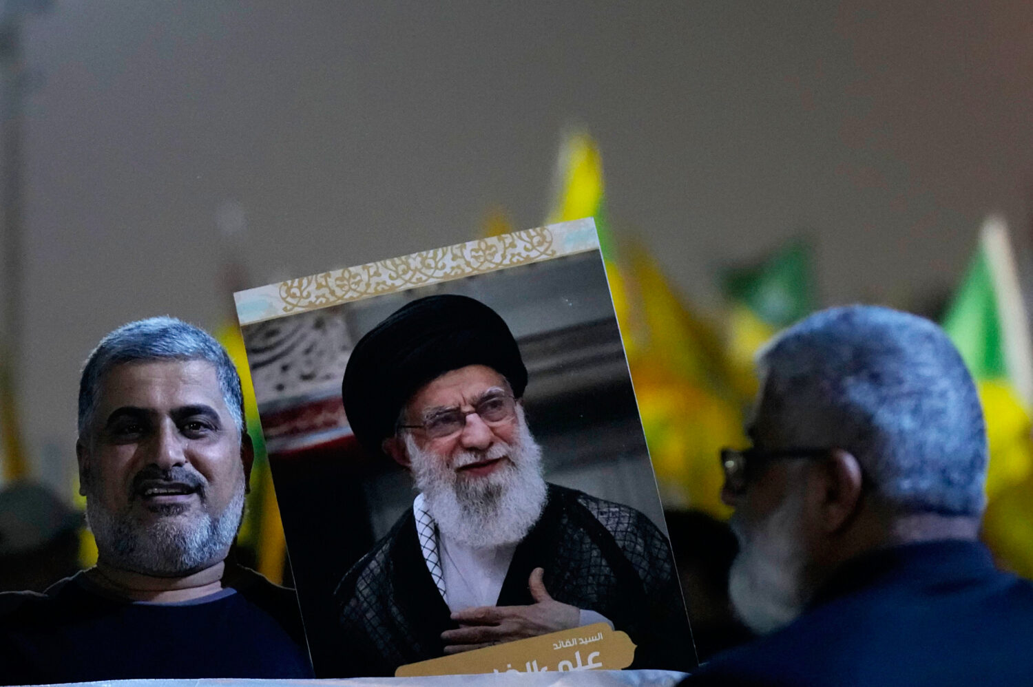 A protester holds a portrait of Iran's Supreme Leader Ayatollah Ali Khamenei during a protest again...