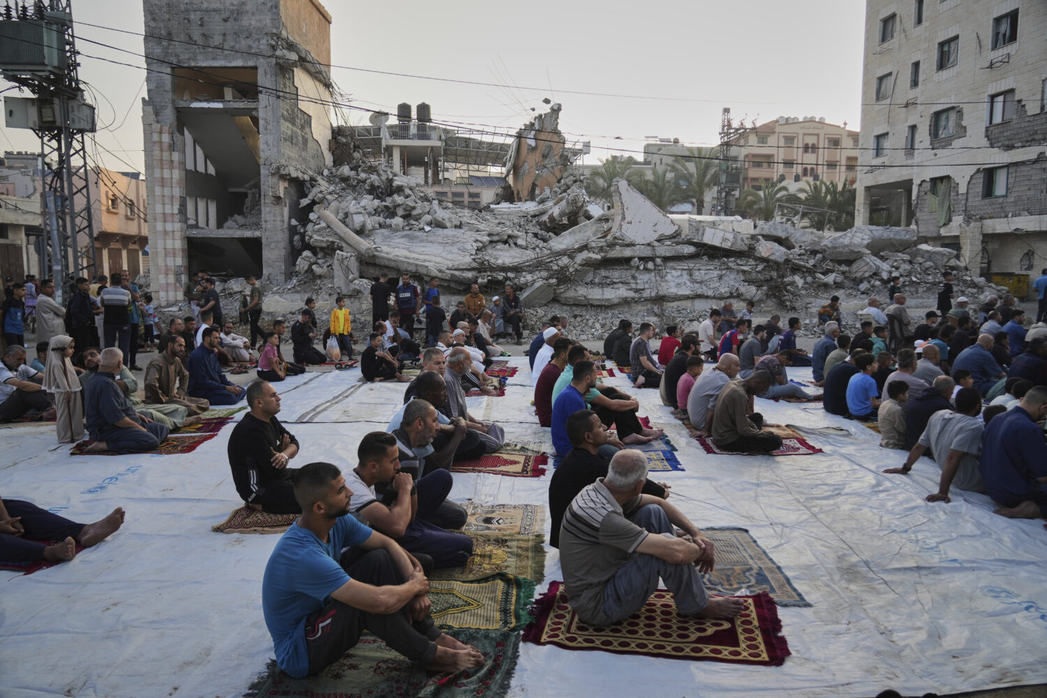 Palestinians gather for Eid al-Adha prayers beside the ruins of a mosque destroyed by Israeli bomba...