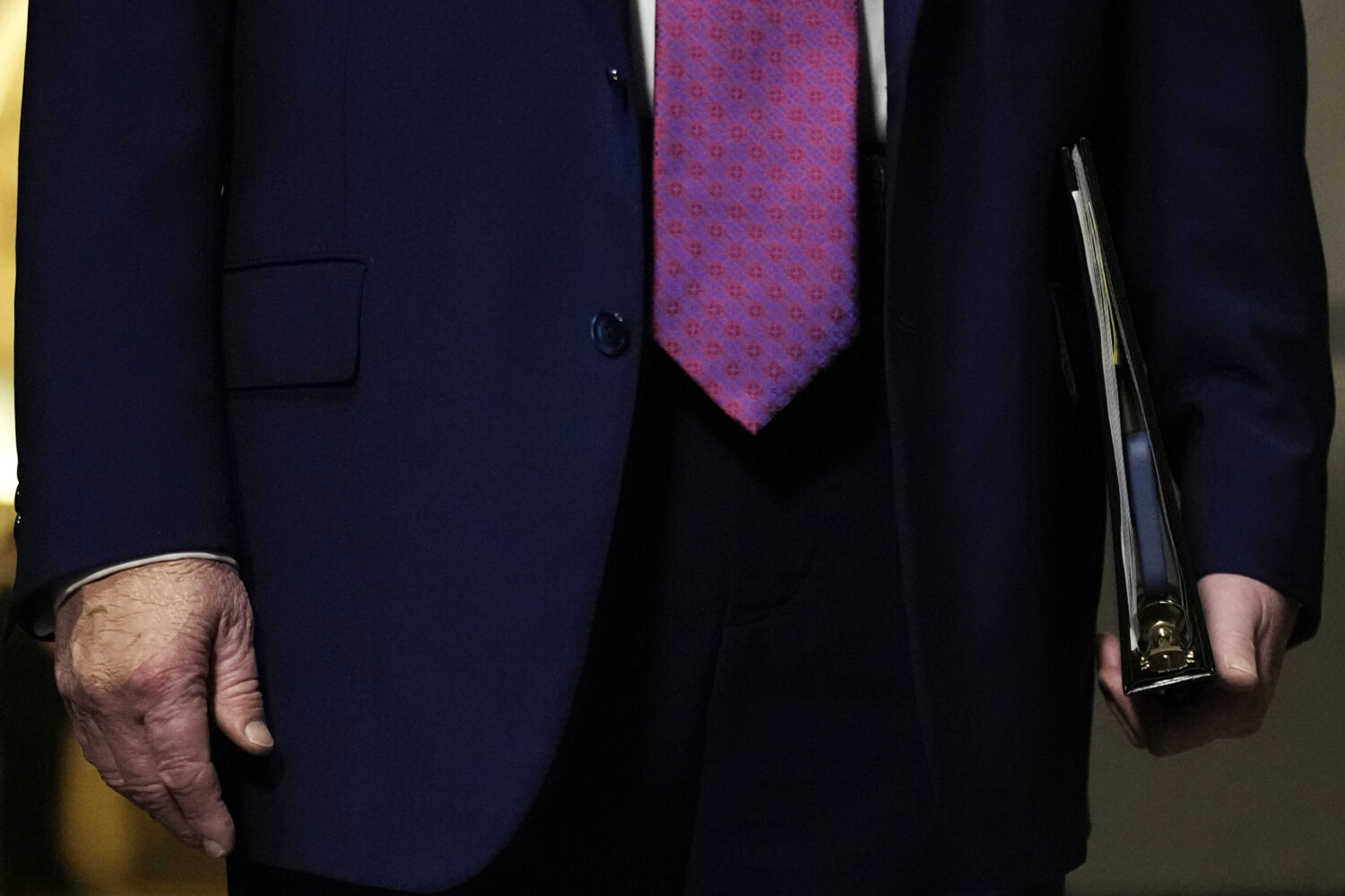 FILE - President Donald Trump holds a binder with a cell phone inside while speaking to reporters b...