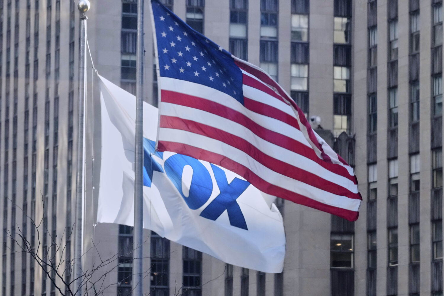 FILE - An American flag and a FOX flag fly outside Fox headquarters, in New York, April 9, 2025. (A...