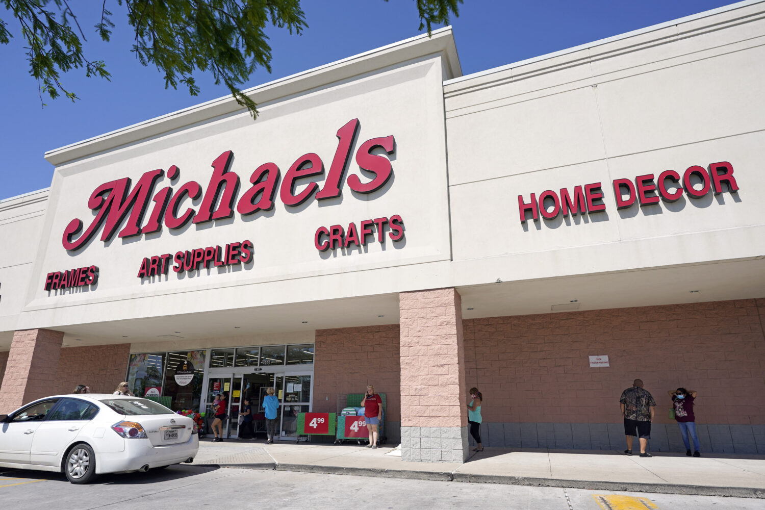 FILE - In this April 24, 2020 file photo, customers lineup outside a Michaels store in Houston. (AP...