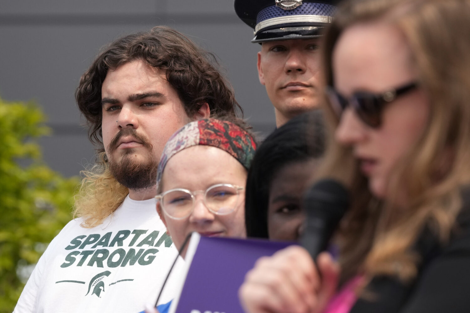FILE - Michigan State University shooting survivor Troy Forbush, left, listens as State Rep. Kelly ...
