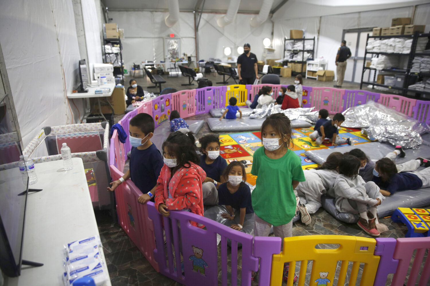 FILE - In this March 30, 2021, file photo, young unaccompanied migrants, watch television inside a ...