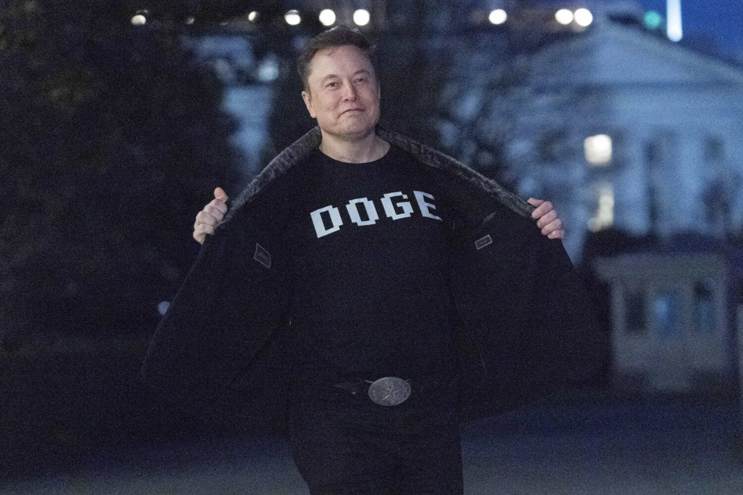 FILE - Elon Musk flashes his t-shirt that reads "DOGE" to the media as he walks on South Lawn of th...