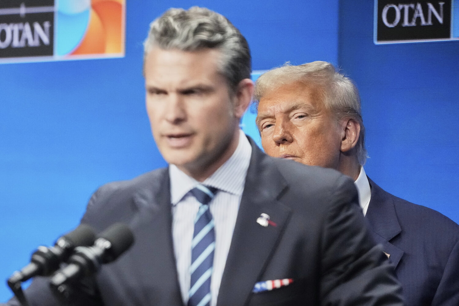 President Donald Trump watches Defense Secretary Pete Hegseth during a press conference after the p...