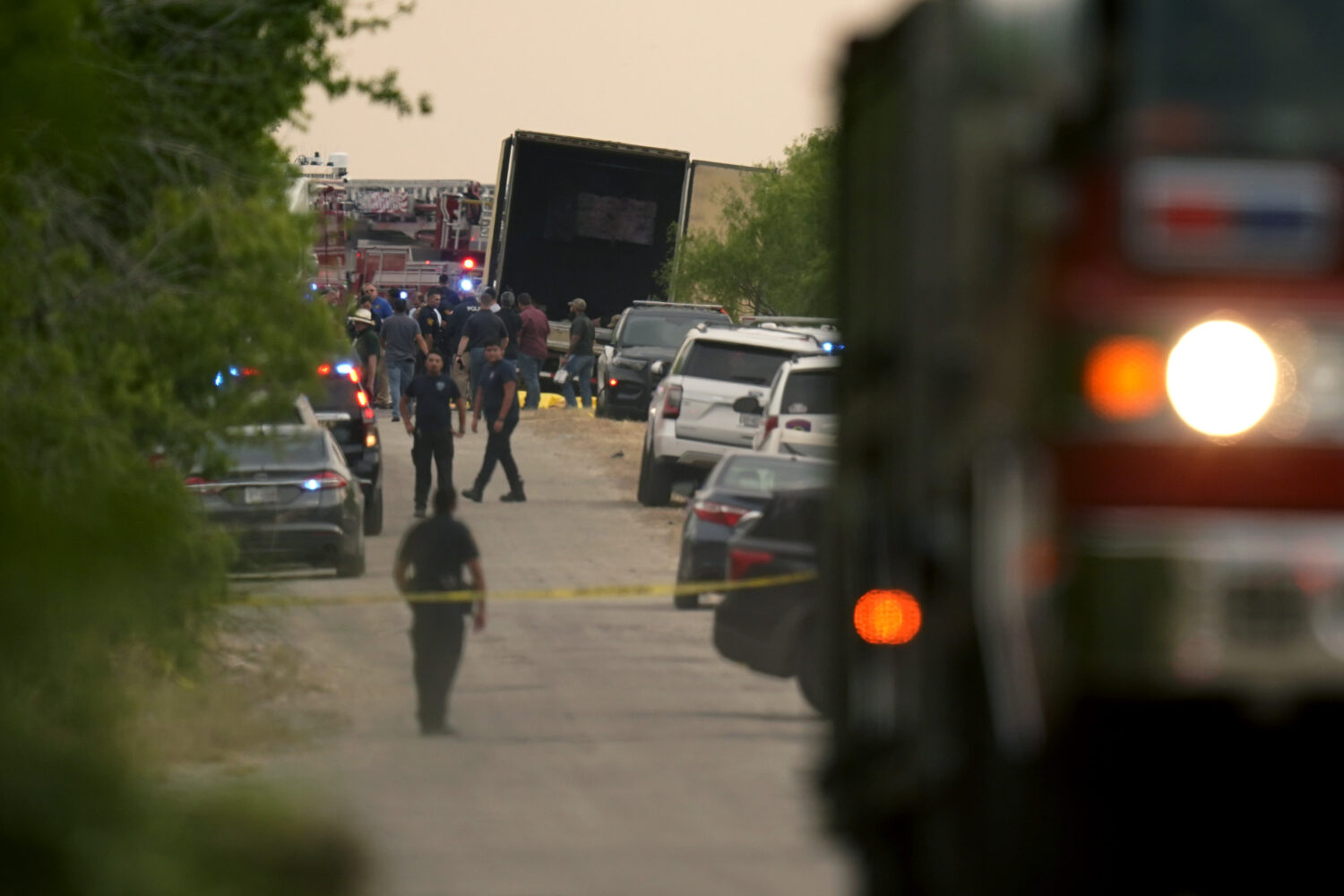 FILE - Body bags lie at the scene where a tractor trailer with multiple dead bodies was discovered,...
