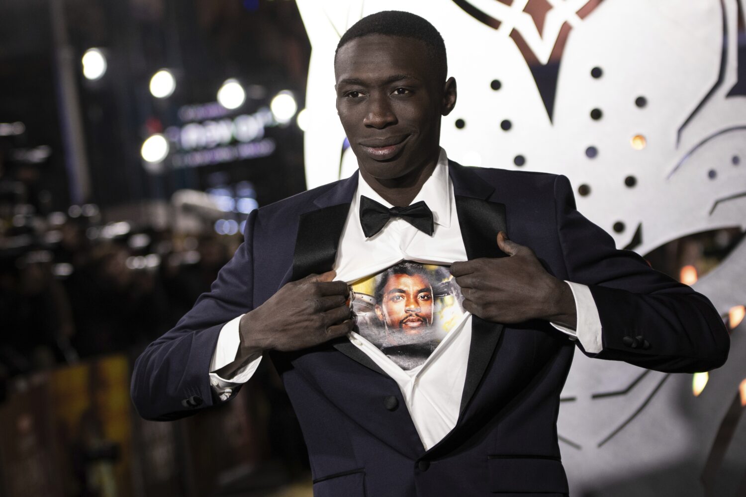 FILE - Khaby Lame opens his shirt to reveal the image of Chadwick Boseman upon arrival for the prem...