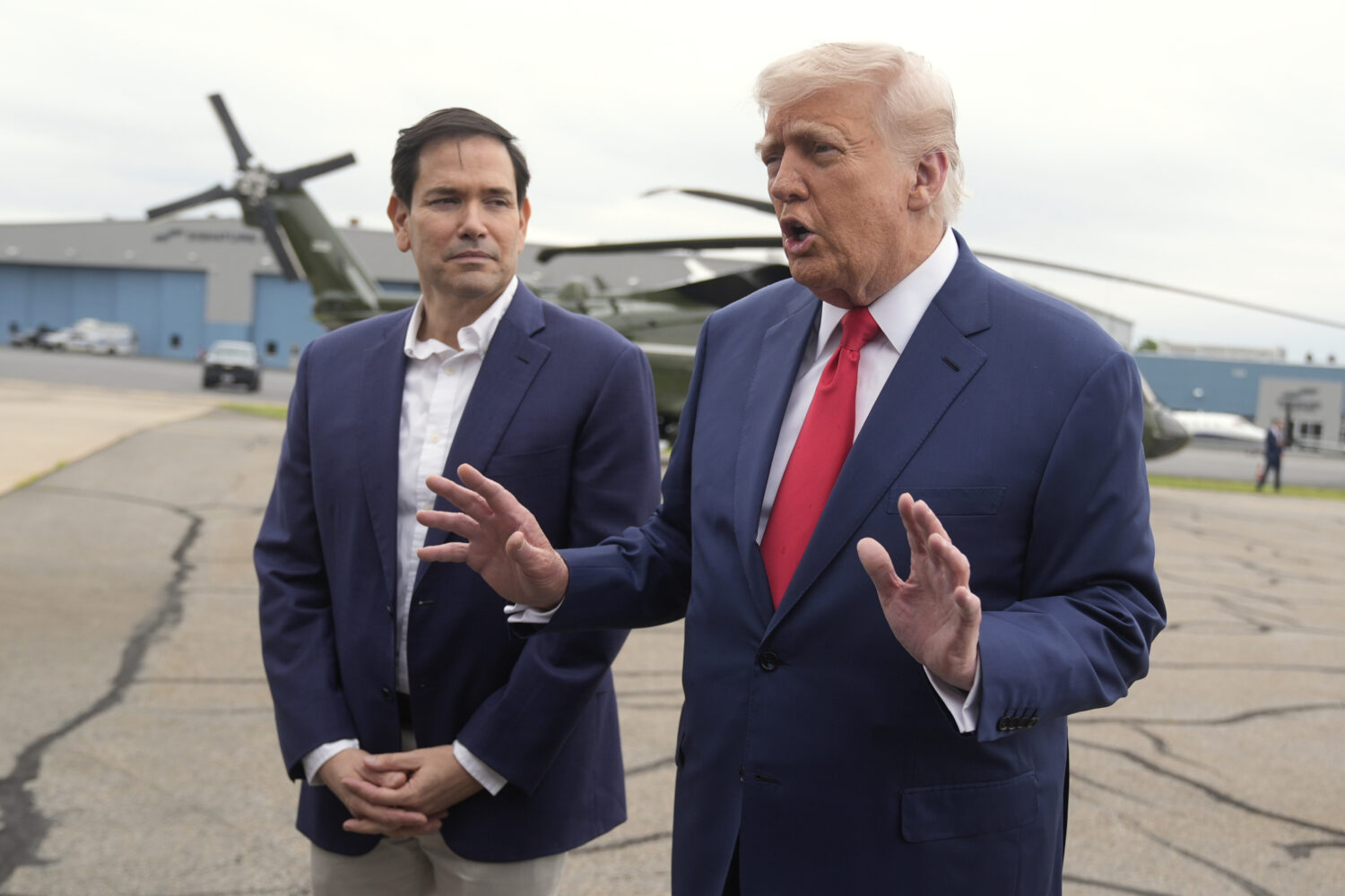 President Donald Trump, right, speaks with reporters as Secretary of State Marco Rubio listens upon...