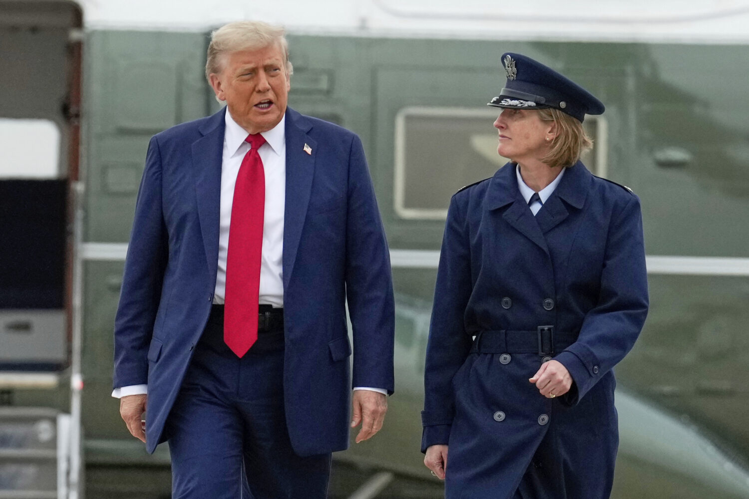 President Donald Trump, left, escorted by Air Force Col. Angela F. Ochoa, Commander, 89th Airlift W...