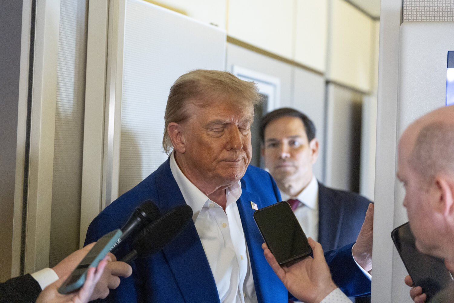 President Donald Trump turns to depart after speaking with reporters on Air Force One while in flig...