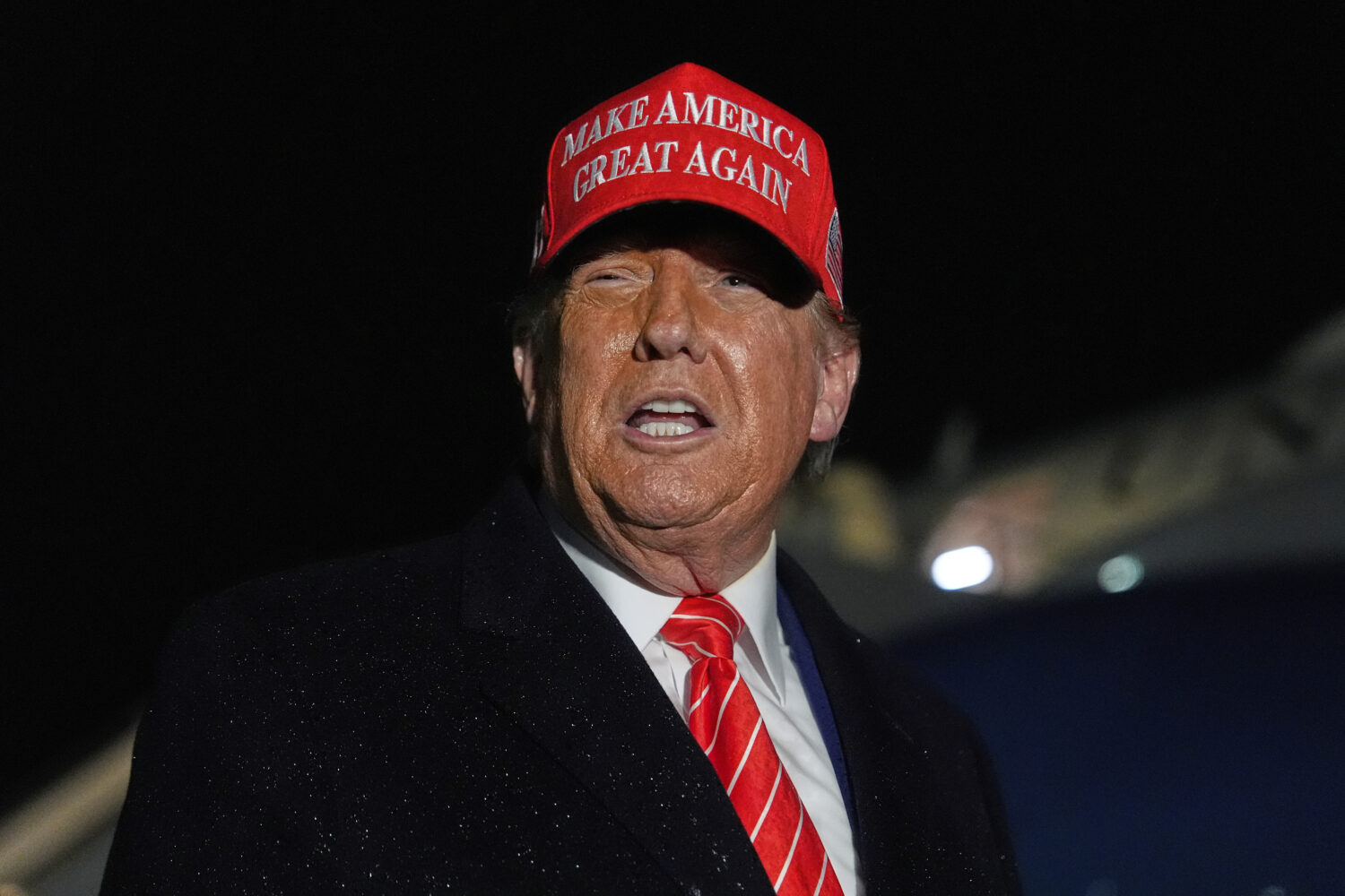 President Donald Trump speaks to reporters in the rain after arriving on Air Force One at Joint Bas...