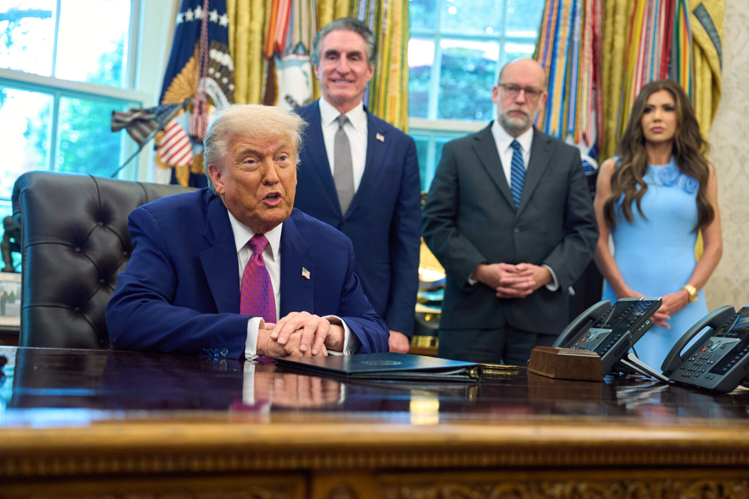 President Donald Trump speaks with reporters in the Oval Office of the the White House, Tuesday, Ju...