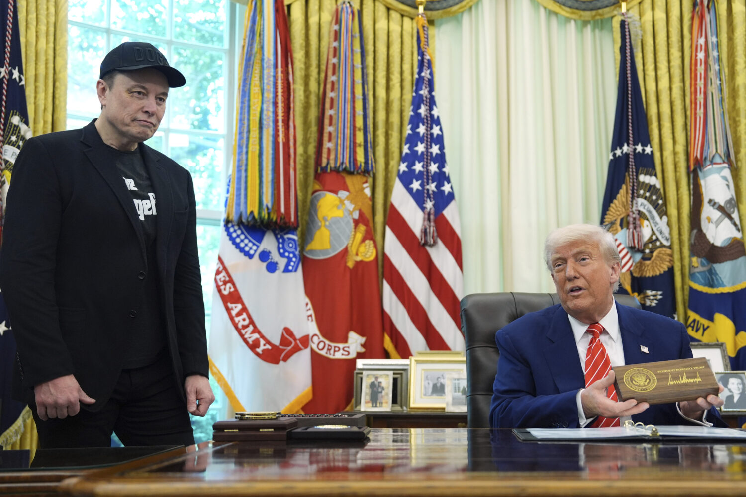 President Donald Trump speaks as he holds a box containing a key before presenting it to Elon Musk,...