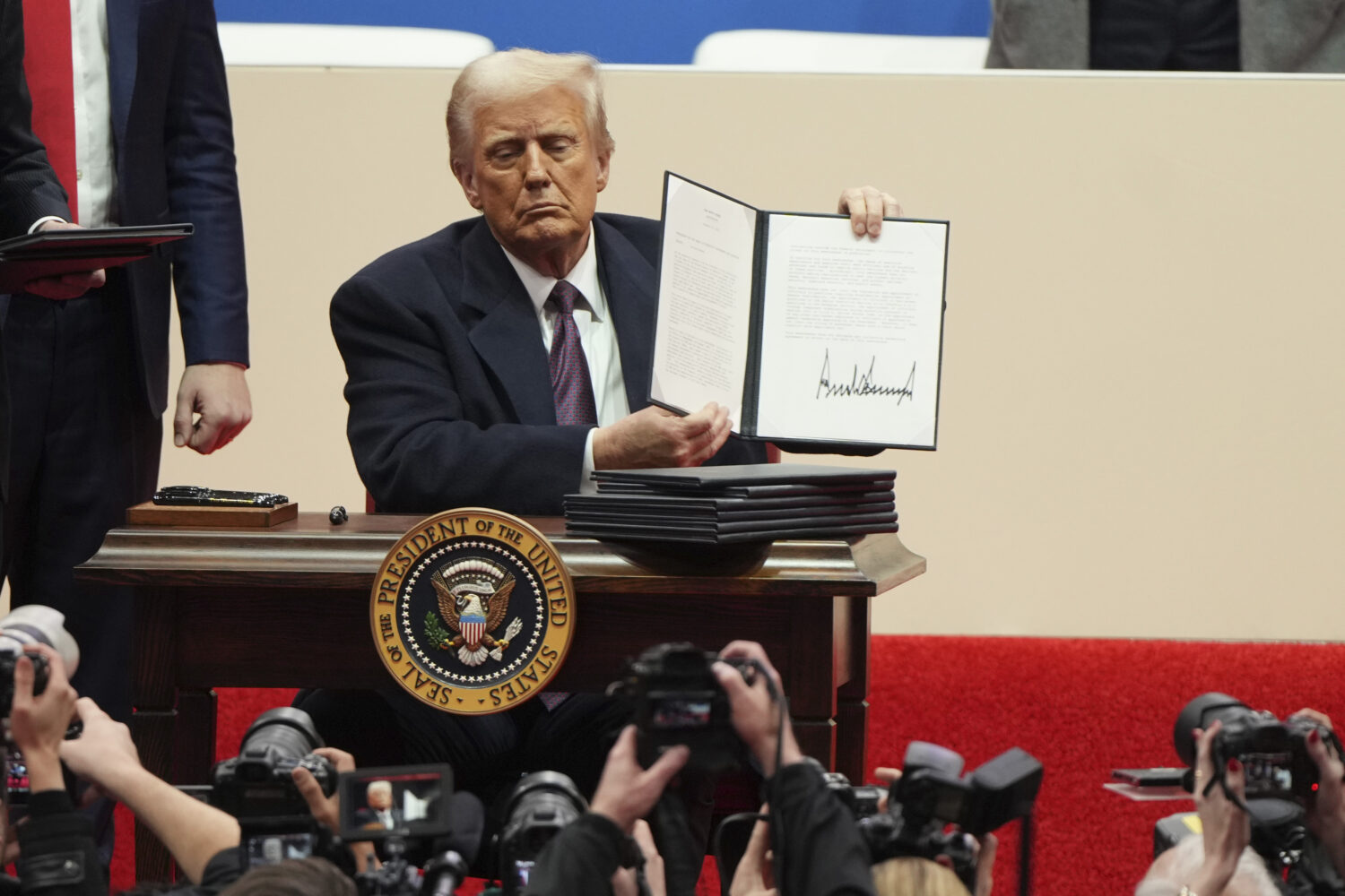 FILE - President Donald Trump holds up an executive order after signing it at an indoor Presidentia...