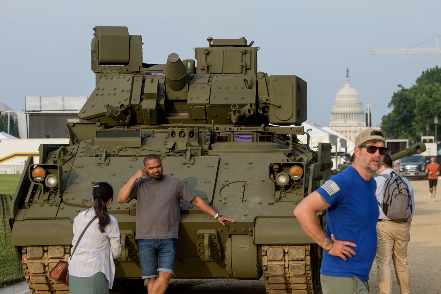 People pass by and take photos with a tank, parked on the National Mall, during preparations for an...