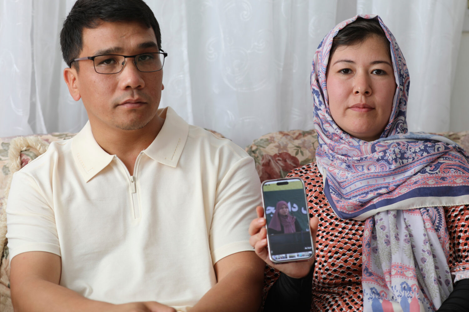 Mohammad Sharafoddin, left, and his wife, Nuriya, right, show a photo of their niece in Afghanistan...