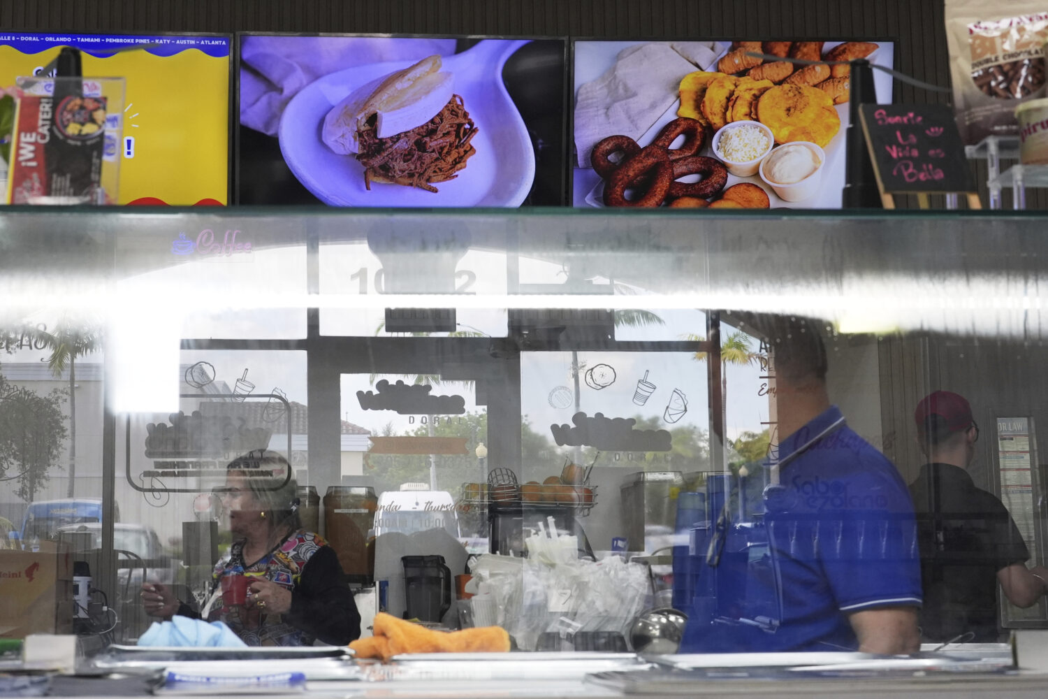 Employees work inside a franchise of "Sabor Venezolano," one of 18 businesses owned by Wilmer Escar...