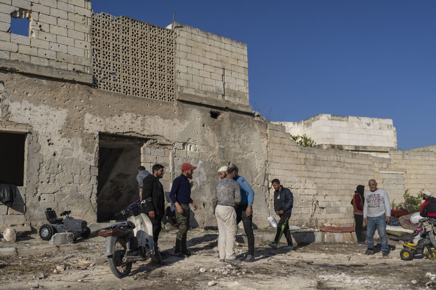 FILE - A family is greeted by locals after their return to their home, in a neighbourhood in Maarat...