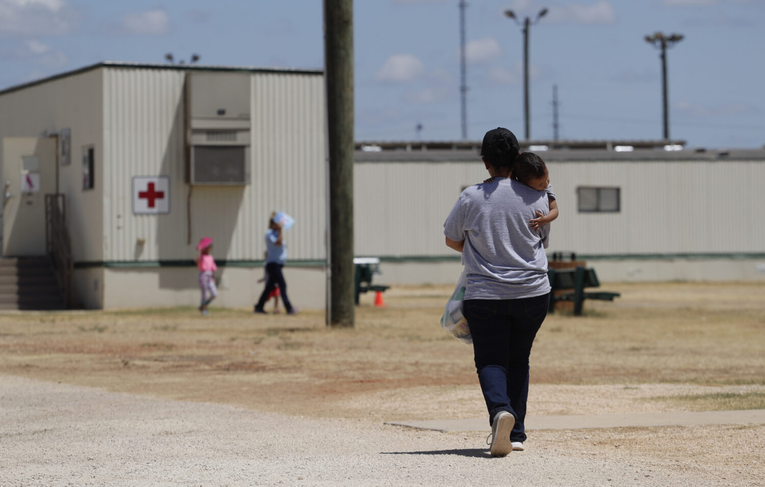 FILE - Immigrants seeking asylum walk at the ICE South Texas Family Residential Center, Aug. 23, 20...