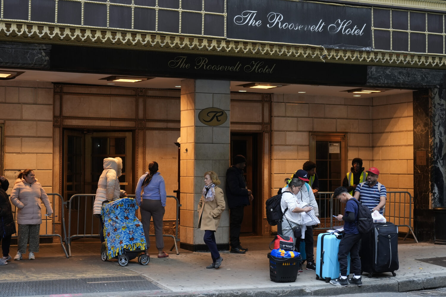 FILE - Members of the Goya family wait for a ride, with their belongings, in front of the Roosevelt...