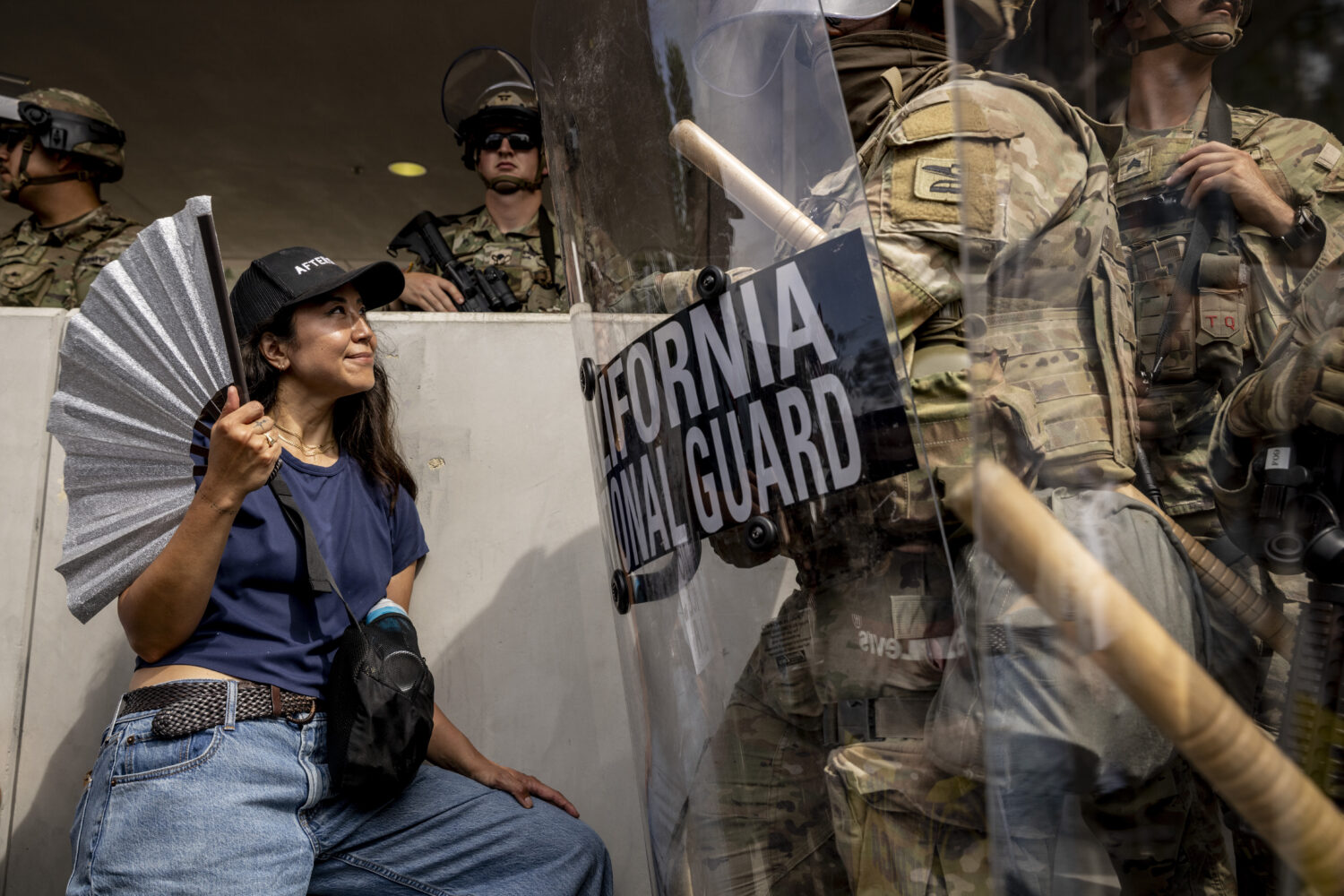 A protester waves a folding fan while standing in front of a California National Guard outside the ...