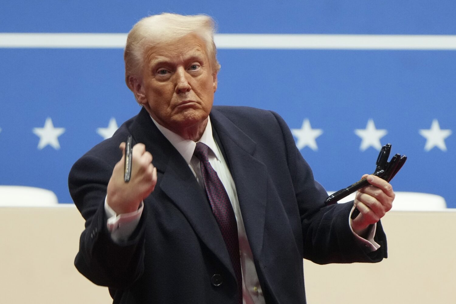 FILE - President Donald Trump throws pens used to sign executive orders to the crowd during an indo...