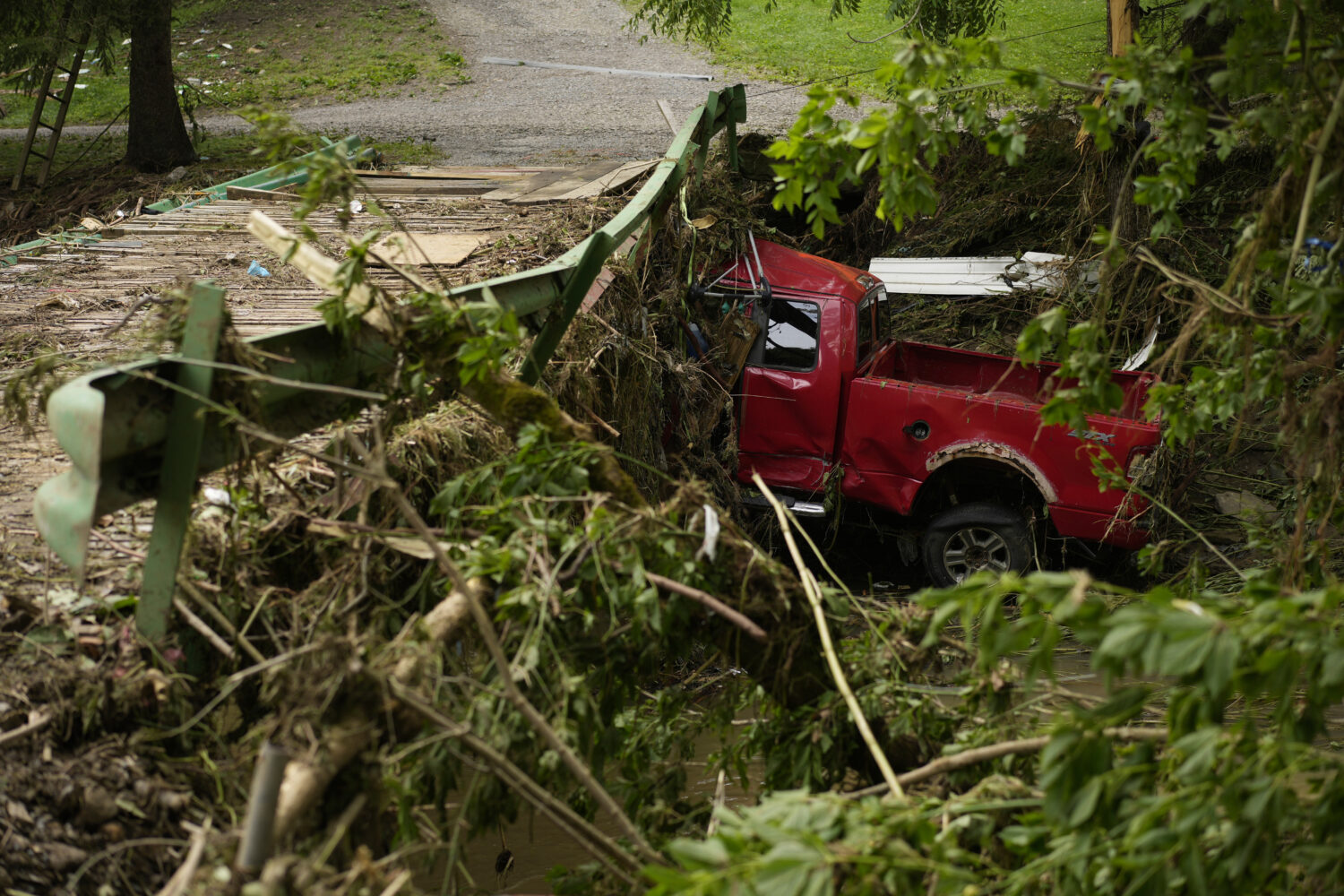 A vehicle sits in flood debris, Monday, June 16, 2025, in Valley Grove, W.Va. (AP Photo/Carolyn Kas...