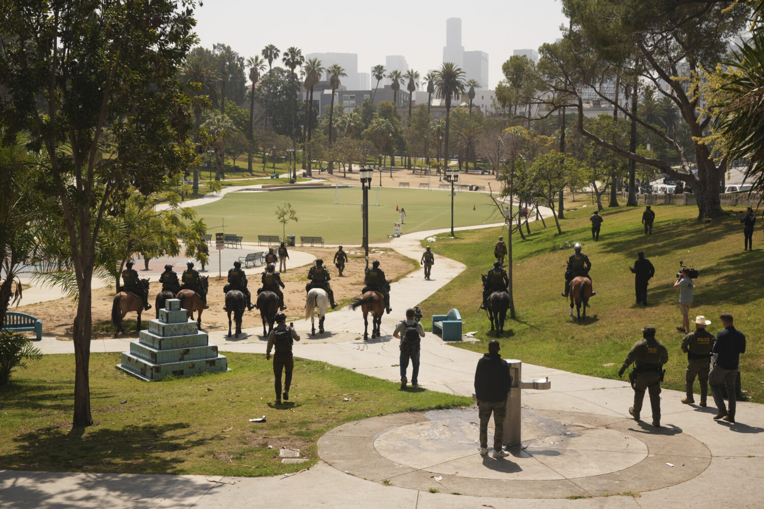 Federal agents ride on horseback at MacArthur Park, Monday, July 7, 2025, in Los Angeles. Their uni...