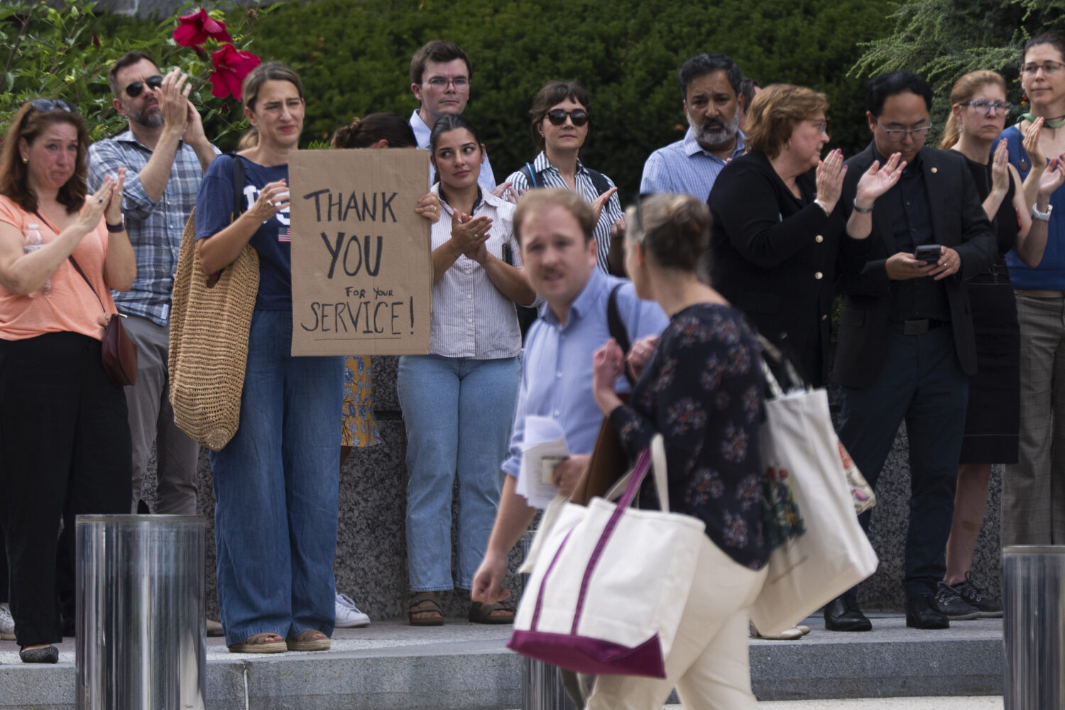 State Department employees applaud as their colleagues walk outside of the State Department headqua...