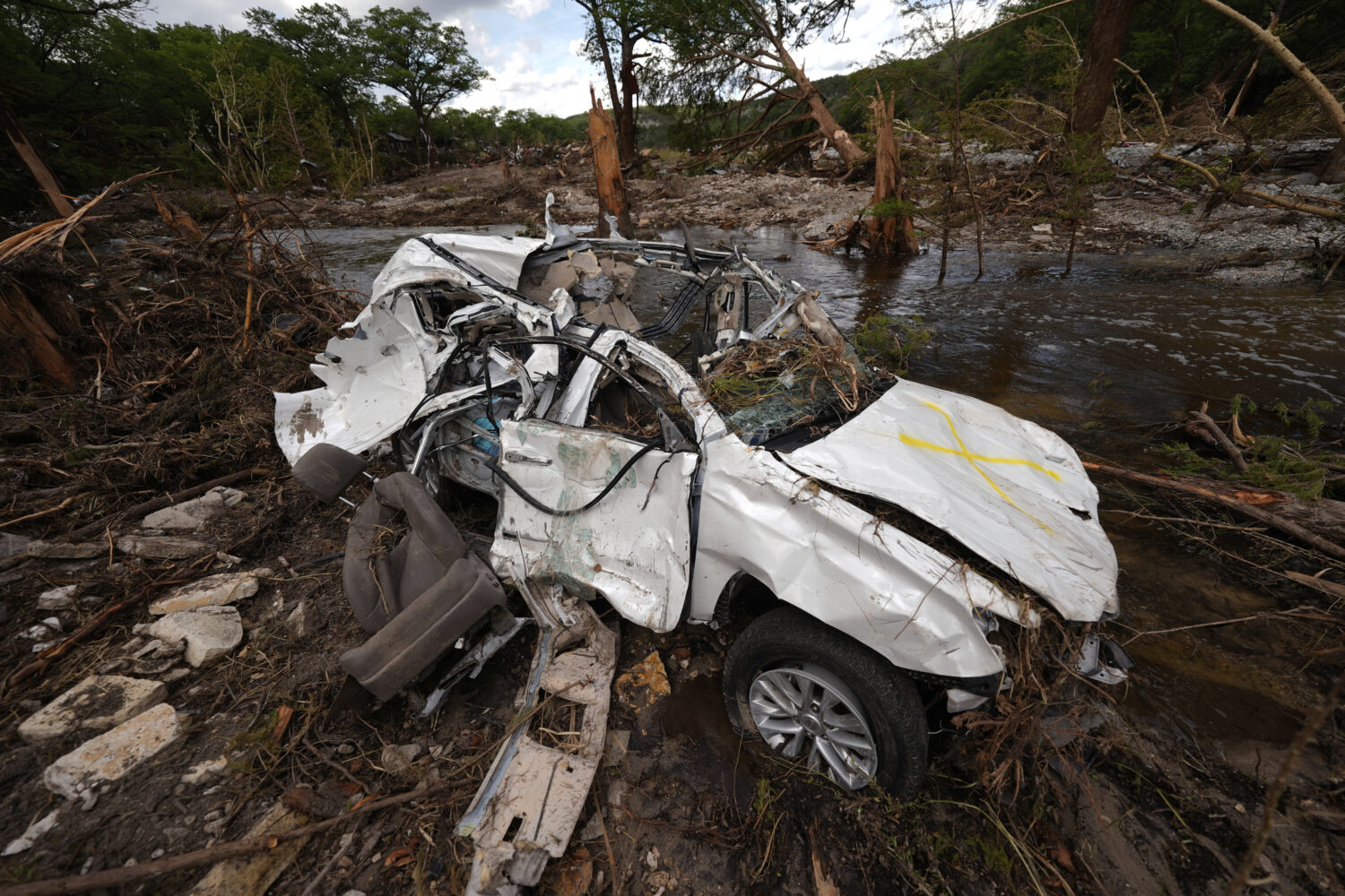 A destroyed vehicle sits next to the Guadalupe River on Wednesday, July 9, 2025, in Hunt, Texas, af...