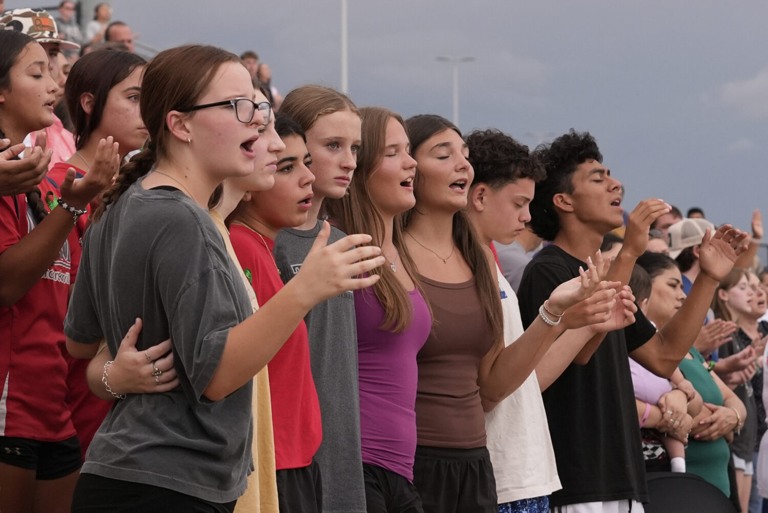 Attendees sing during a vigil for flooding victims at Tivy Antler Stadium on Wednesday, July 9, 202...