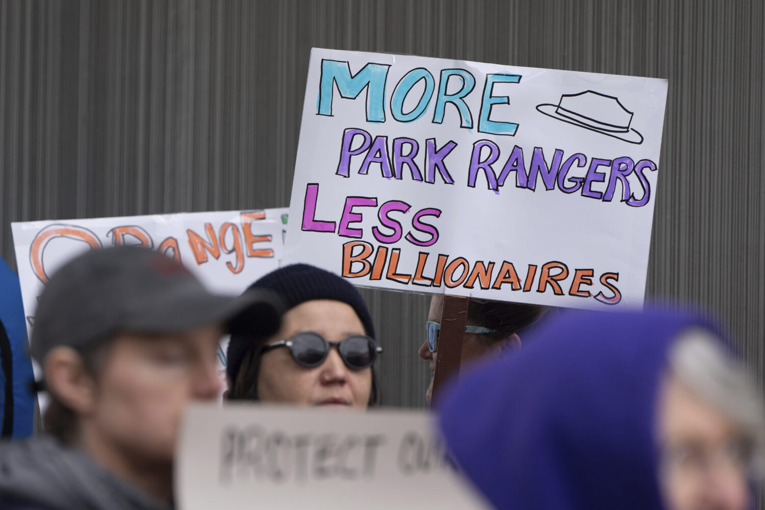 FILE - People hold signs during a protest outside the annual Alaska Sustainable Energy Conference, ...