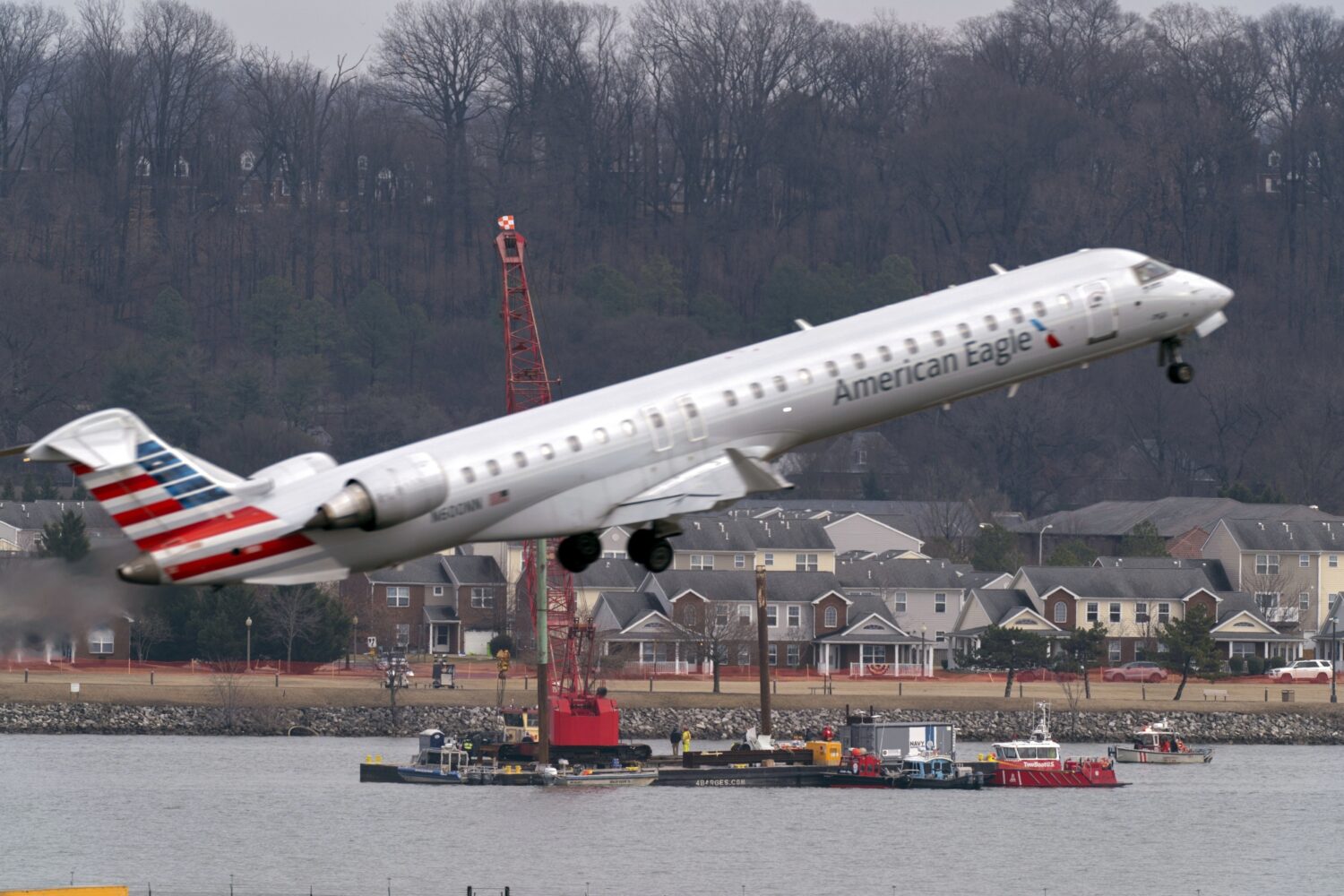 FILE - Salvage crews work on recovering wreckage near the site in the Potomac River of a mid-air co...