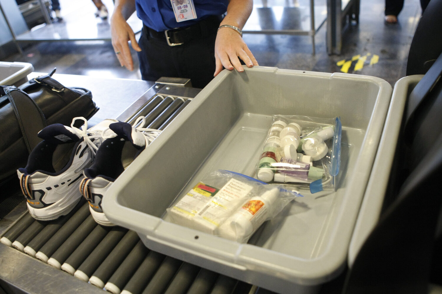 FILE - Shoes and small liquid containers are placed in bins to be screened by TSA Supervisor Jennif...
