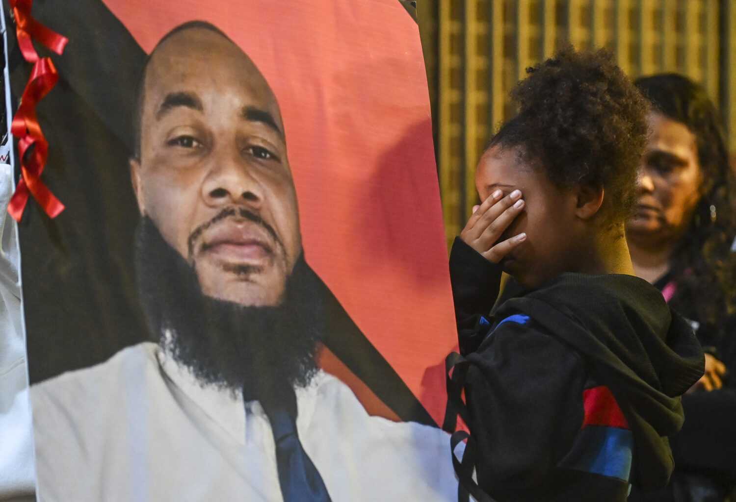 FILE - A girl holds a hand over her eyes during a vigil for Stephen Perkins outside Decatur, Ala. C...