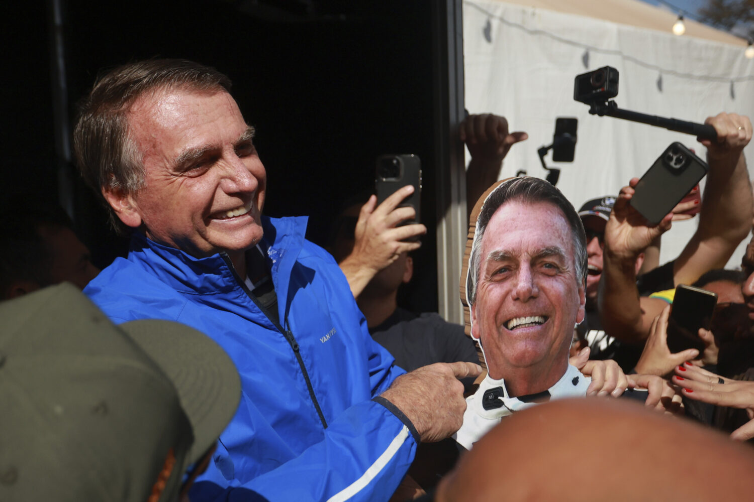 Brazil's former President Jair Bolsonaro points a photo of him during a motorcycle caravan by suppo...