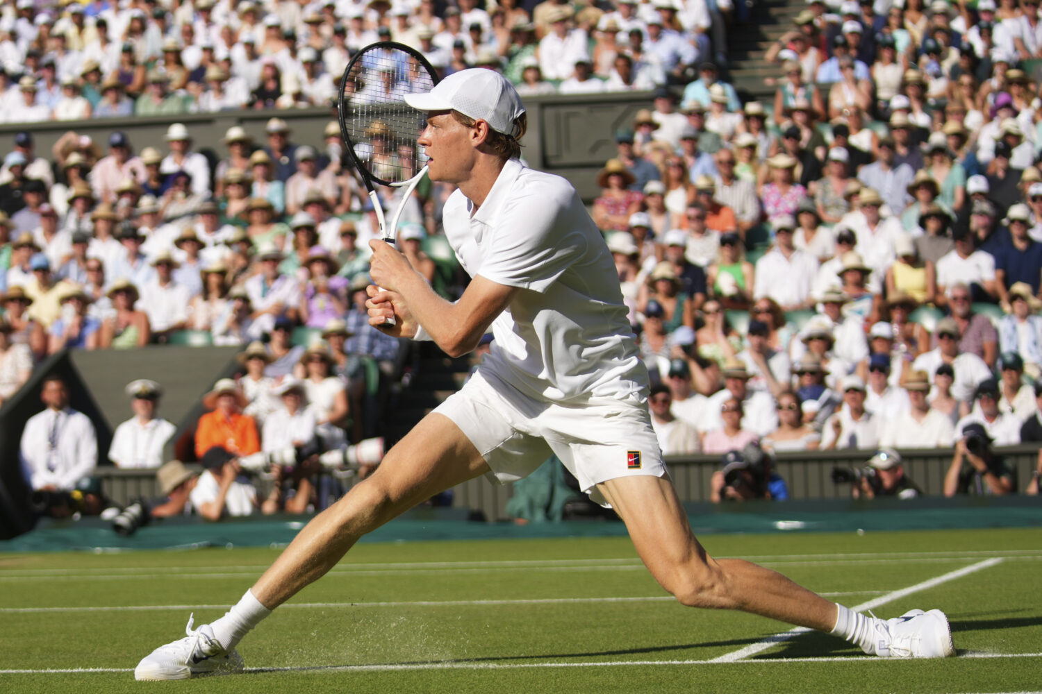 Jannik Sinner of Italy slides as he plays a return to Novak Djorkovic of Serbia during the men's se...