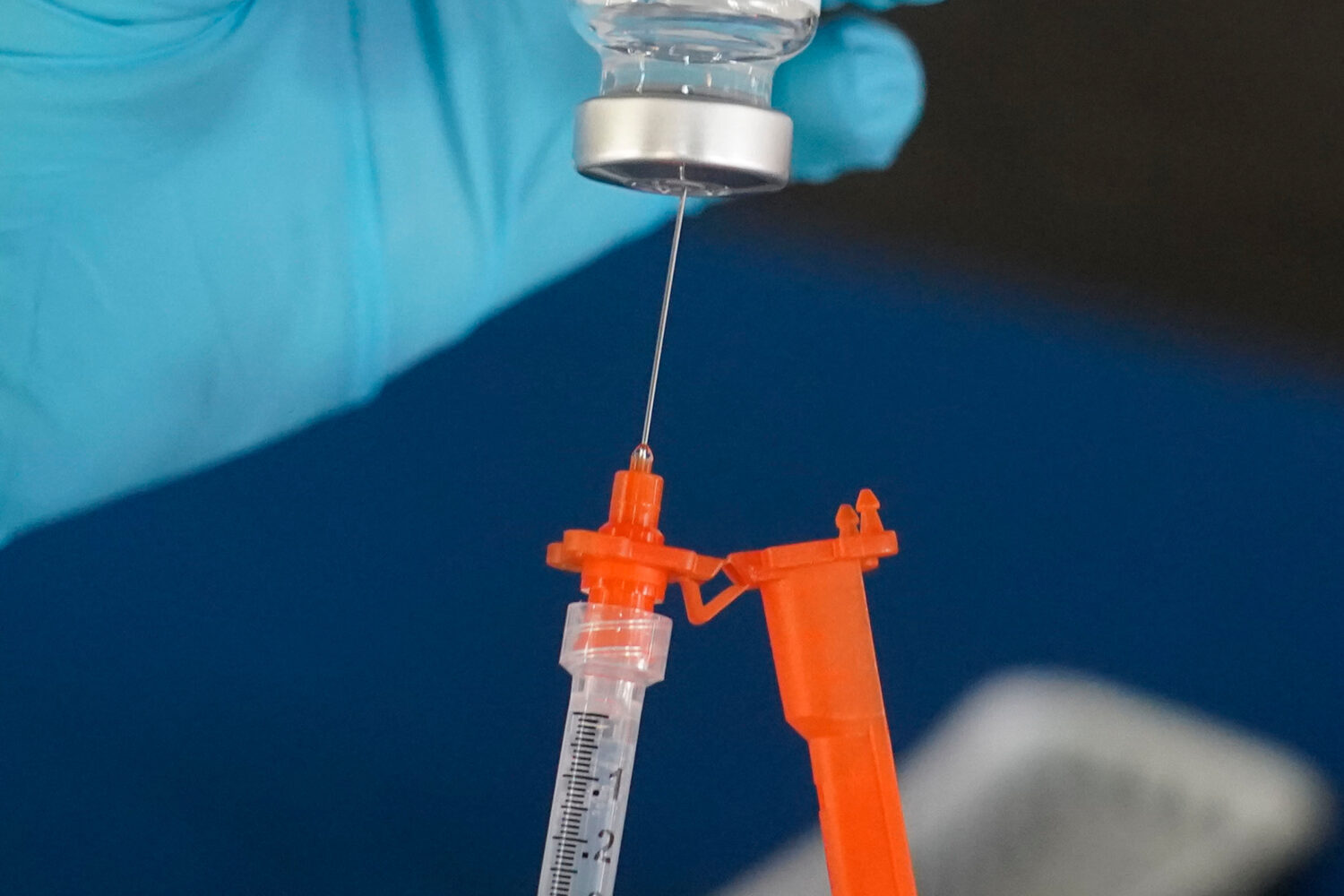 FILE - A nurse loads a syringe with a COVID-19 booster vaccine at an inoculation station in Jackson...