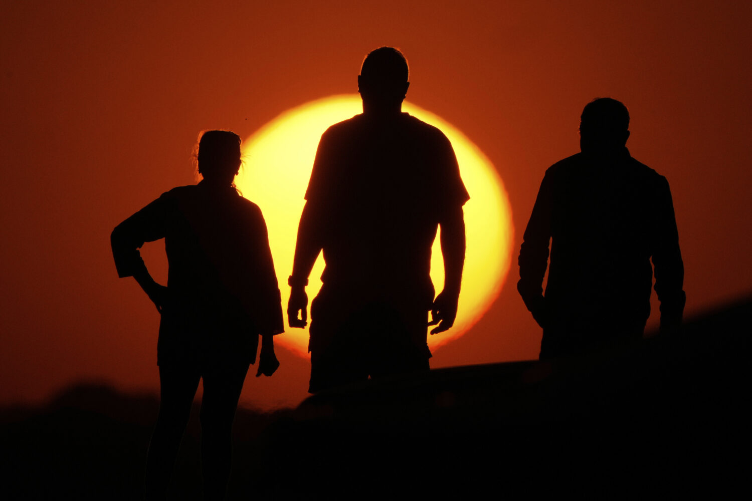 FILE - People watch the sunset from the Liberty Memorial grounds in Kansas City, Mo., May 12, 2025....