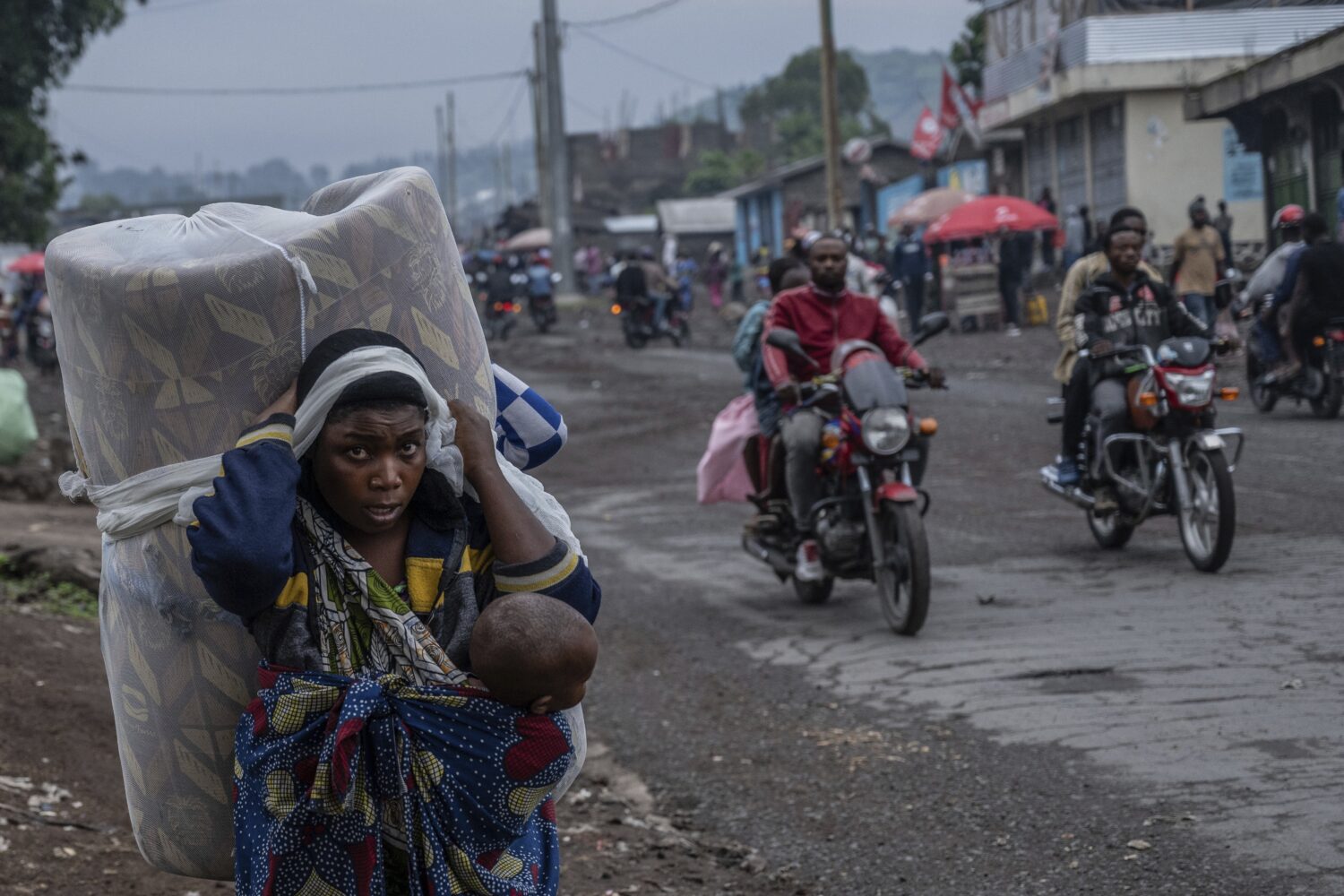 FILE - People displaced by the fighting with M23 rebels make their way to the center of Goma, Democ...