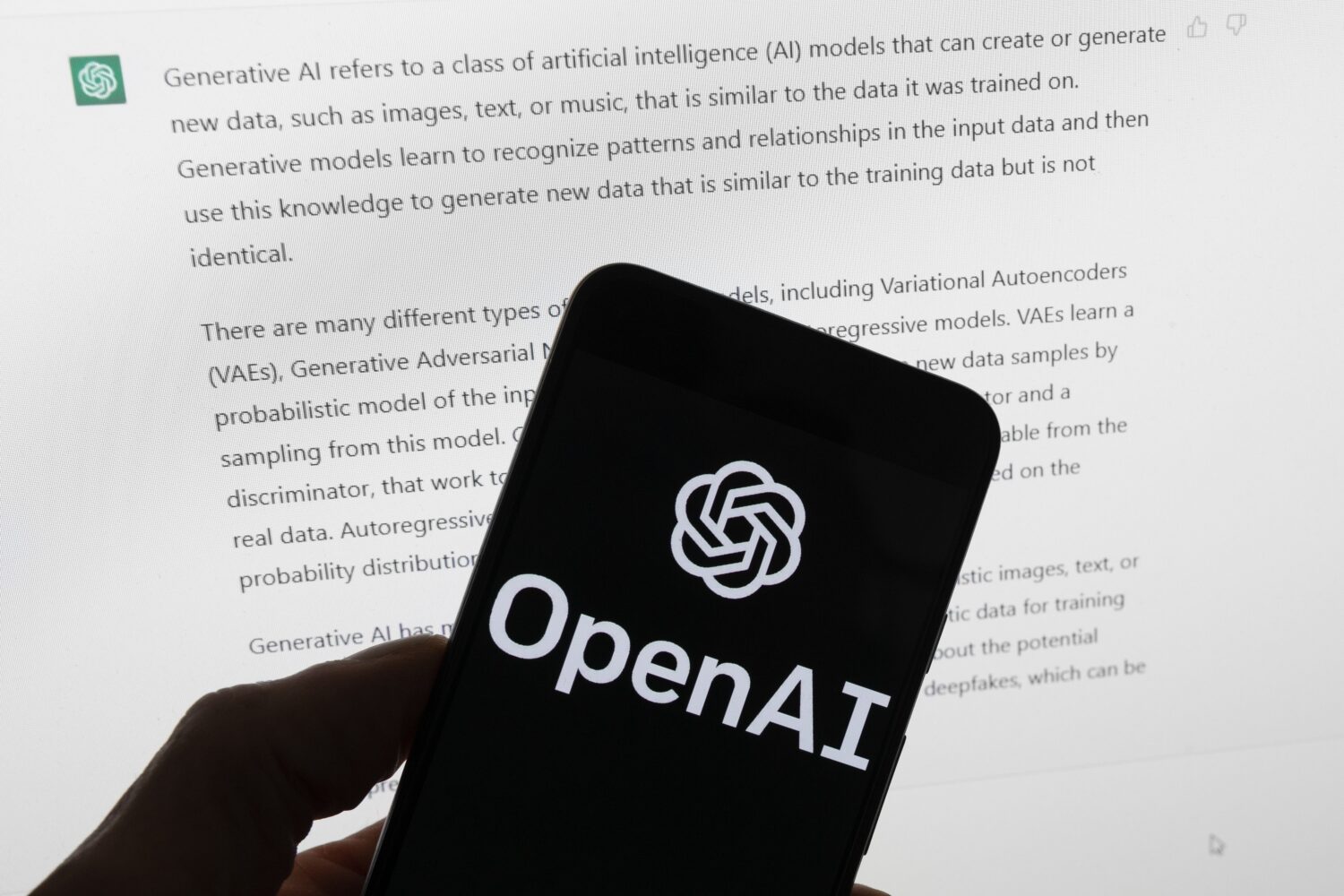 FILE - The OpenAI logo is seen on a mobile phone in front of a computer screen displaying output fr...
