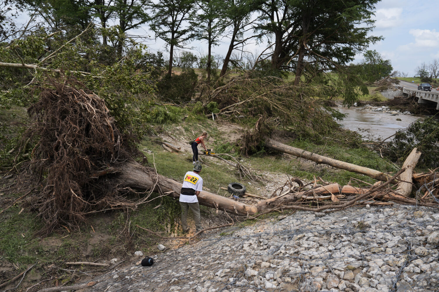 Hayley Bosworth, back, and Simon Ball, foreground, cut tree branches during clean-up efforts after ...