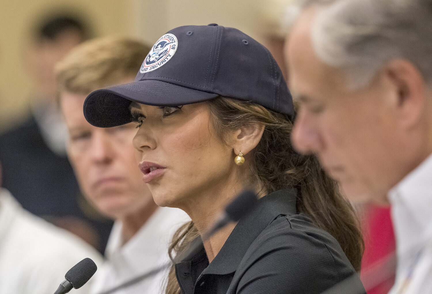 Homeland Security Secretary Kristi Noem, center, and Texas Gov. Greg Abbott, right, discuss the ong...