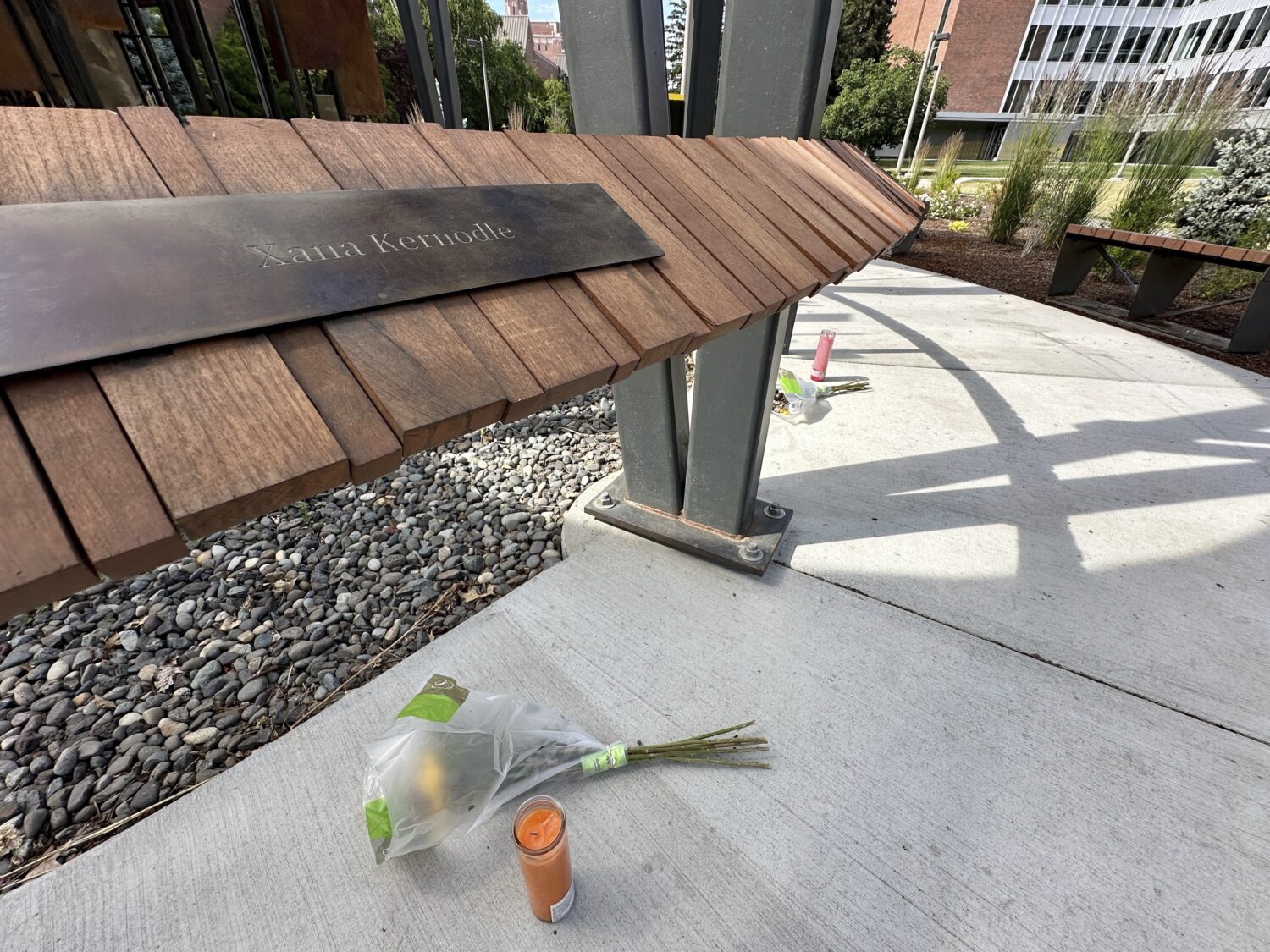 A flower and a candle were left below the name plaque for Xana Kernodle, one of the four University...