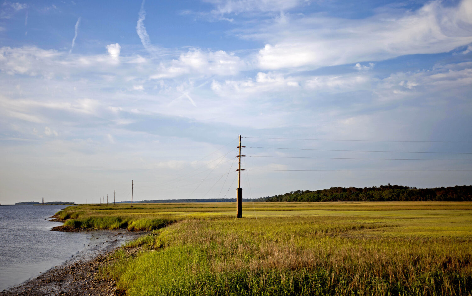 FILE - In this May 16, 2013, file photo, a utility pole stands in the middle of a marsh at sunset o...