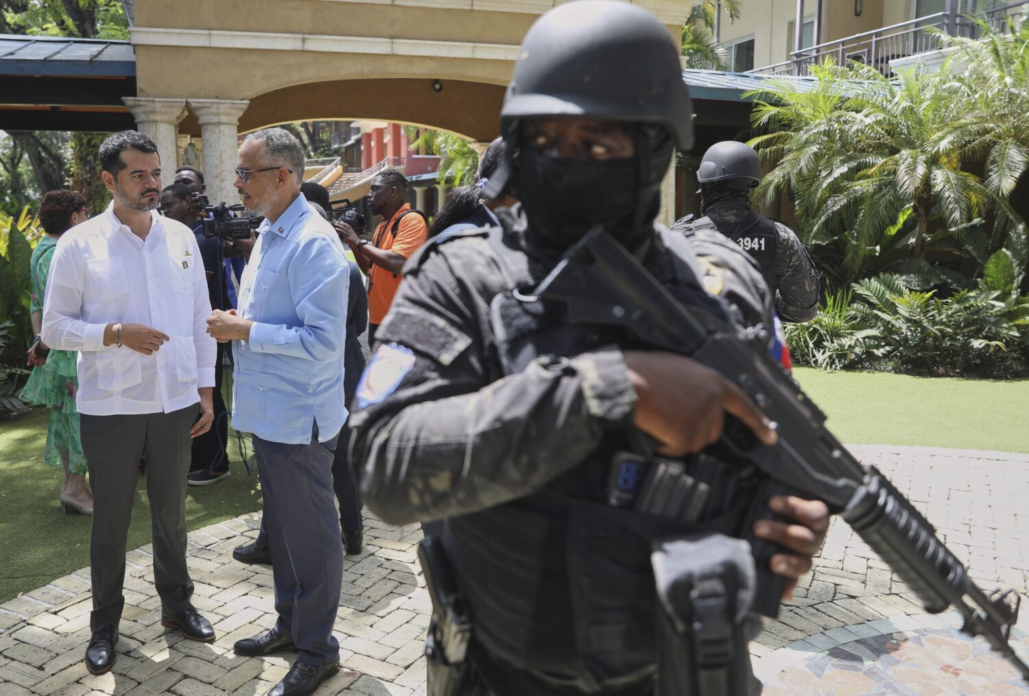 Security guards stand watch as Haiti's Prime Minister Alix Didier Fils-Aime, center, talks with the...