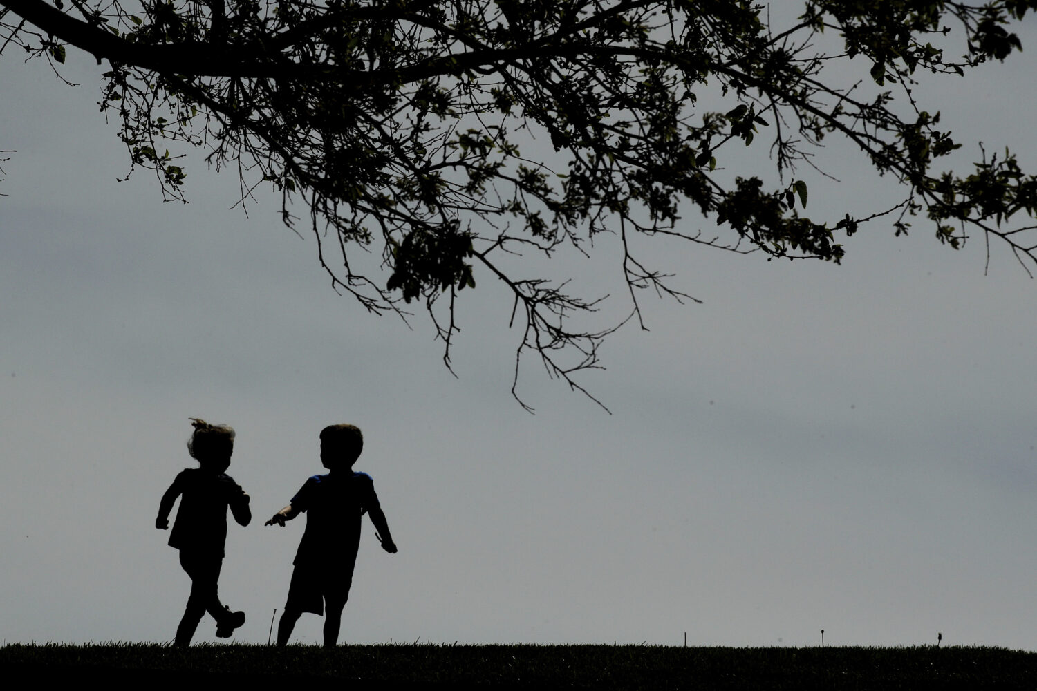 FILE - Children run on the lawn at the Liberty Memorial in Kansas City, Mo., on April 28, 2020. (AP...